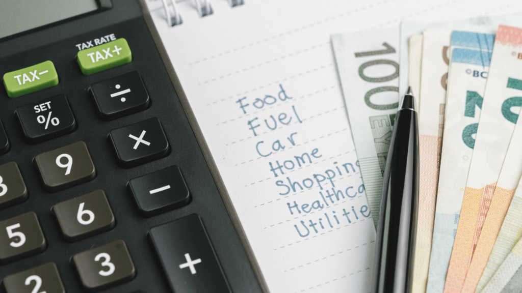Calculator with a note pad and cash euros next to it.
