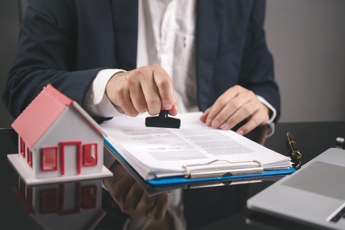 Businessman,Hand,Using,Rubber,Stamp,On,Legal,Contract,Document,With